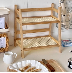 Detail view of cream rattan double-layer desktop storage rack with a wood frame