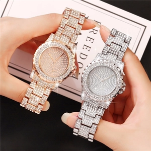 Close-up of rose gold and silver luxury watches with full crystal pavé diamond finish