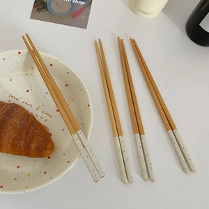 Close-up of Japanese style bamboo chopsticks with colorful polka dot handles on a table