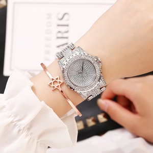 Close-up of luxury full diamond women's watch and star bracelet set on wrist