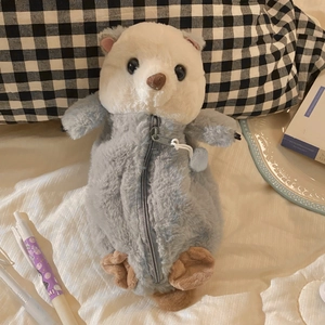 Detail of cute sea otter plush pencil case on a cozy desk setup with books and pens
