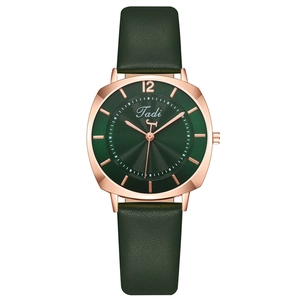 Fashionable women's watch with rose gold square case and green leather strap on white background
