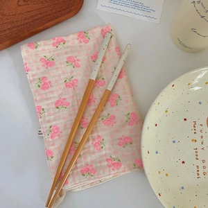 Close-up of bamboo chopsticks with colorful polka dots and a floral cotton napkin