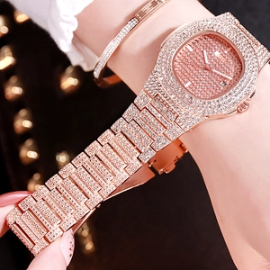 Gros plan d'une montre octogonale en or rose sertie de cristaux avec dateur