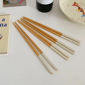 Close-up of five pairs of Japanese style bamboo chopsticks with colorful polka dot tips