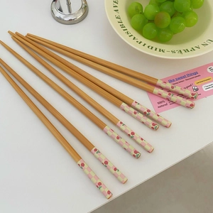 Detail shot of bamboo chopsticks featuring cute cherry patterns and plaid handles