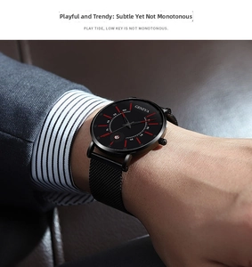 Detail of minimalist wormhole concept watch with black mesh strap and red hour markers