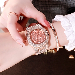Détails d'un coffret montre en or rose avec strass et bijoux assortis portés au poignet