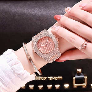 Détail macro d'une montre de luxe en or rose avec cristaux, bracelet et bague papillon