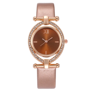 Détail de montre en or rose avec lunette en strass, cadran marron et bracelet en cuir rose