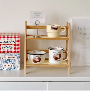 Detail view of double-layer cream rattan desk shelf with woven texture and ceramic mugs