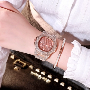 Détail d'une montre sertie de diamants or rose et bracelet avec affichage de date