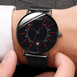 Close-up of minimalist black dial watch with red markers and stainless steel mesh strap