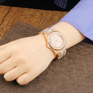 Macro shot of rose gold fashion watch fully encrusted with shimmering crystals on the band