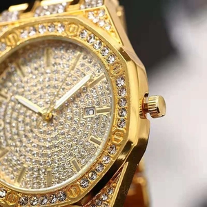 Macro detail of luxury gold iced-out octagonal watch with crystal dial and date window
