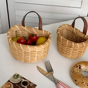 Detail of hand-woven basket with brown leather handle and reinforced metal rivets