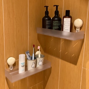 Detail of wall-mounted frosted bathroom shelf with strong vacuum suction hooks