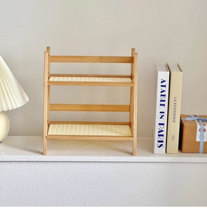 Detail of a 2-tier cream rattan desktop organizer with natural wood frame for storage