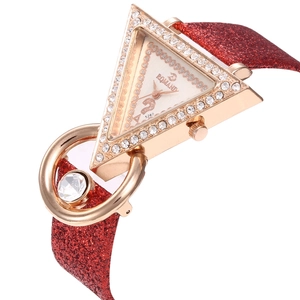 Details von luxuriöser Dreiecksuhr mit Strasssteinen und rotem Glitzerarmband