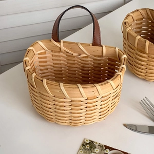 Detail of hand-woven ginger garlic basket with leather handle and rivet fastening