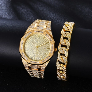Luxury gold men's watch with crystals and matching chain bracelet set on black stand