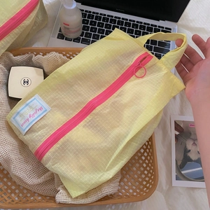 Close-up of yellow plaid organizer bag with pink zipper and portable handle detail