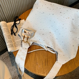 Detail of white star-print canvas tote bag with mini pouch and metallic chain