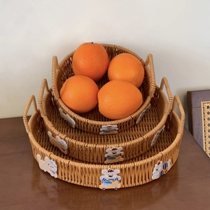 Close-up of three nesting woven fruit baskets with cute cartoon animal patches and handles