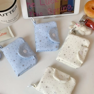 Close-up of mini star pattern coin purses in light blue and cream with snap buttons
