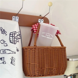 Detail showing handwoven rattan picnic basket with dual handles and natural texture finish