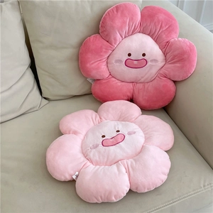 Plush flower seat cushions with cartoon faces in pink colors on a cozy sofa decor