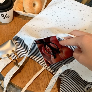 Close-up of white canvas star tote with heart pouch and striped lining detail