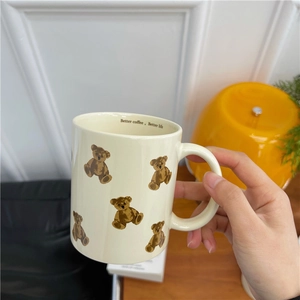 Cream vintage ceramic bear mug with Better Coffee Better Life slogan in hand