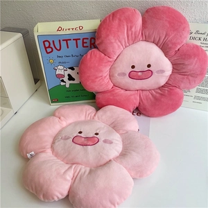 Detail of pink flower plush pillow featuring soft fabric and cute embroidered smiley face