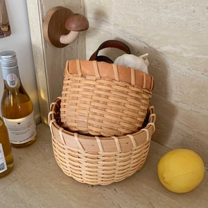 Close-up of two handcrafted wooden woven baskets for kitchen garlic and ginger storage