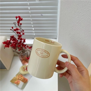 Cream vintage bear ceramic mug with 'warm life' text shown in a cozy home setting