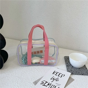 Detail of transparent PVC waterproof bag with purple piping and coral woven handles