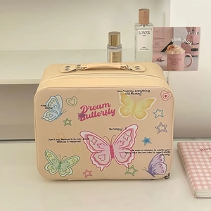 Macro detail of cream makeup bag featuring colorful butterflies and Dream Butterfly text