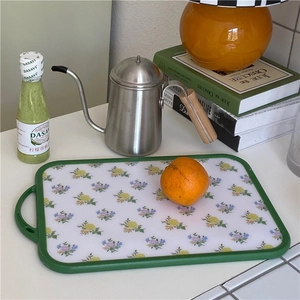 Detail of floral kitchen cutting board with green edges and convenient hanging handle