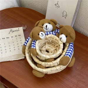 Nesting set of three handmade woven bear storage baskets in varying sizes on a wooden desk
