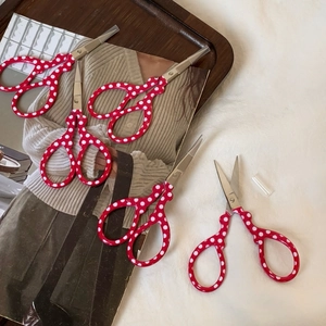 Macro shot of red polka dot handle embroidery scissors with stainless steel blades