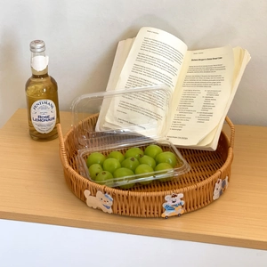 Round faux rattan woven tray with cartoon animal details and dual handles for fruit storage
