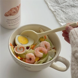 Creamy white irregular ceramic cereal bowl with matching spoon and artistic print