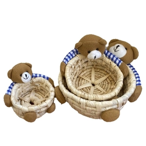 Three-piece set of handmade straw storage baskets with cute bear design and blue plaid detail