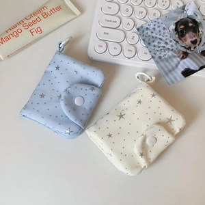 Close-up of small fabric card pouches with star patterns in light blue and beige colors