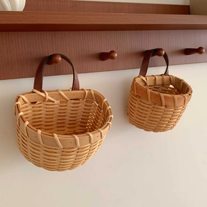 Two-piece set of handmade woven ginger and garlic baskets with brown leather hanging loops