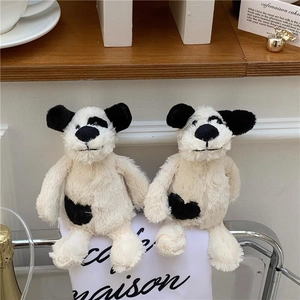 Gros plan de chiots en peluche noir et blanc doux avec une texture moelleuse sur tissu