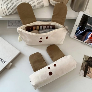 Detail of cute canvas puppy stationery bags showing the rabbit ears and zipper texture