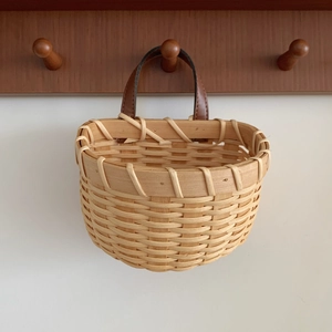 Detail of hand-woven ginger garlic basket with leather handle and fine wall-mount texture