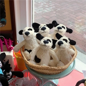 Mignon chiot en peluche à taches noires et blanches avec oreilles tombantes